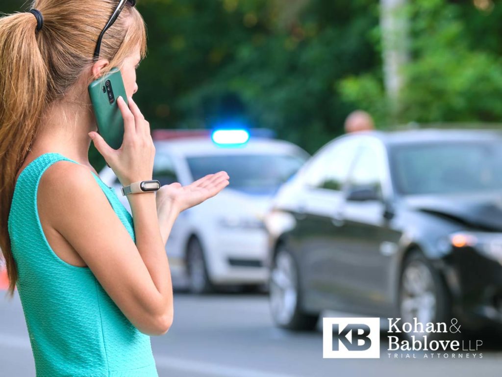 Car Accident Victim Contacting Insurance with Police in Background