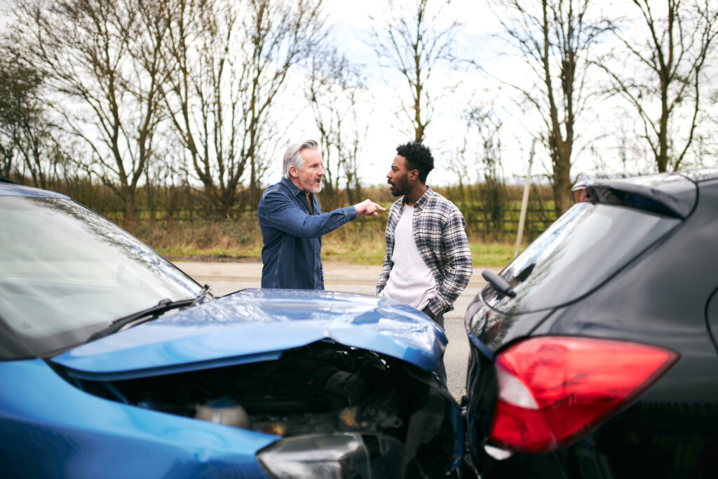 Senior Male Driver Arguing Over Blame For Car Accident With A Younger Male Motorist